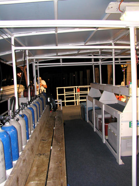 One side of the dive deck with tanks and bench on one side, utility table opposite.